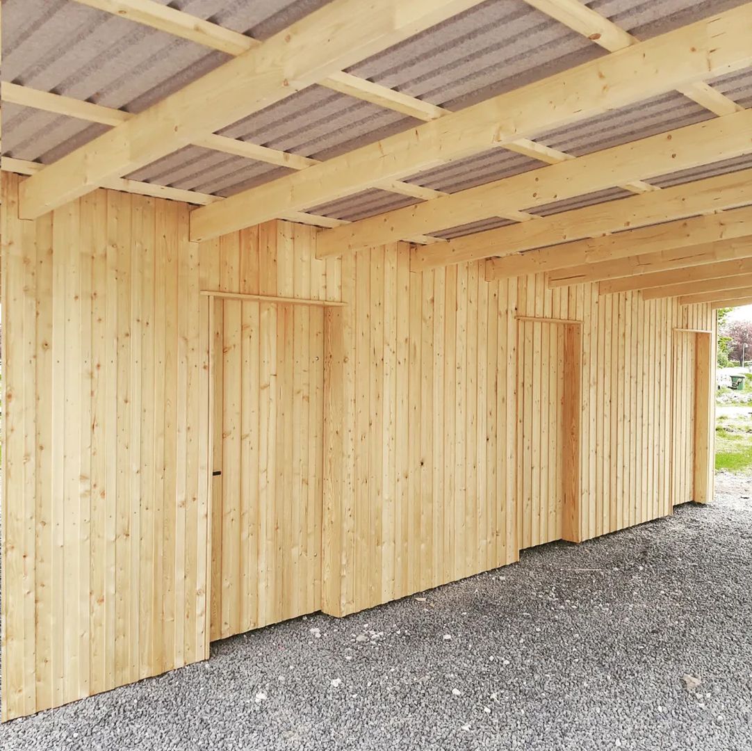 Carport aus hellem Holz auf hellgrauem Schotter